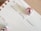 A calendar page open to Thursday the 19th with handwritten notes reading 'Influencer Holiday Takeovers.' The page is decorated with two small pink Christmas ornaments.