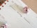 A calendar page open to Thursday the 19th with handwritten notes reading 'Influencer Holiday Takeovers.' The page is decorated with two small pink Christmas ornaments.