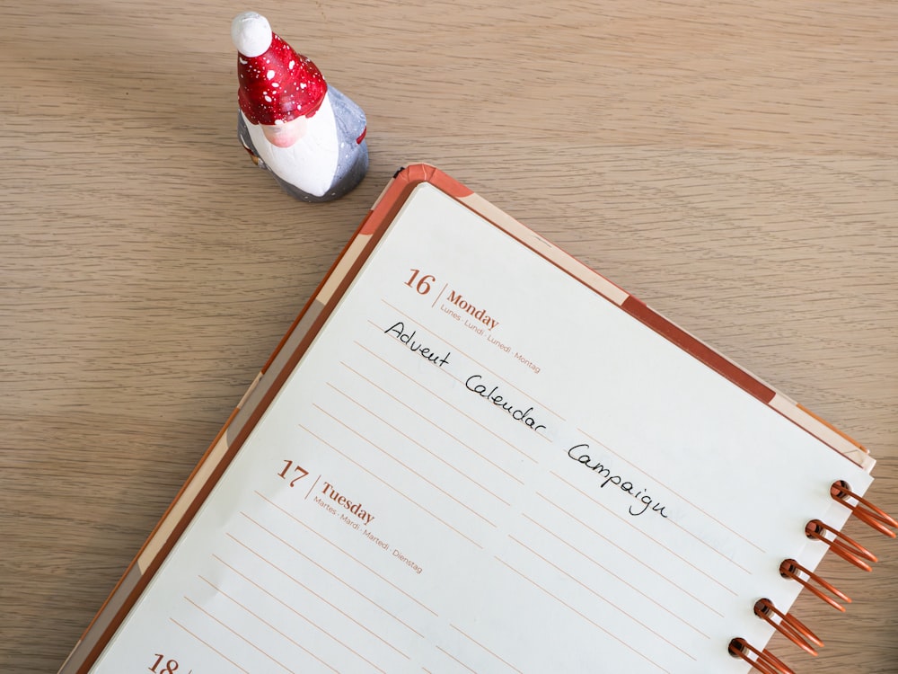 a notepad with a red and white santa hat on top of it