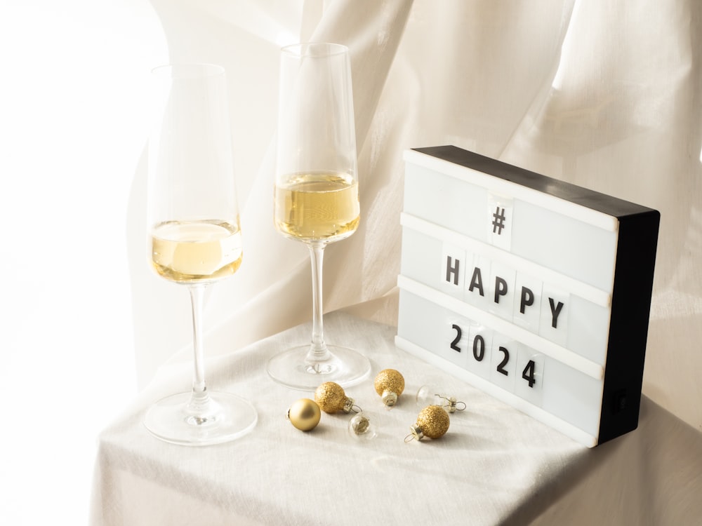 a happy new year sign next to a glass of wine