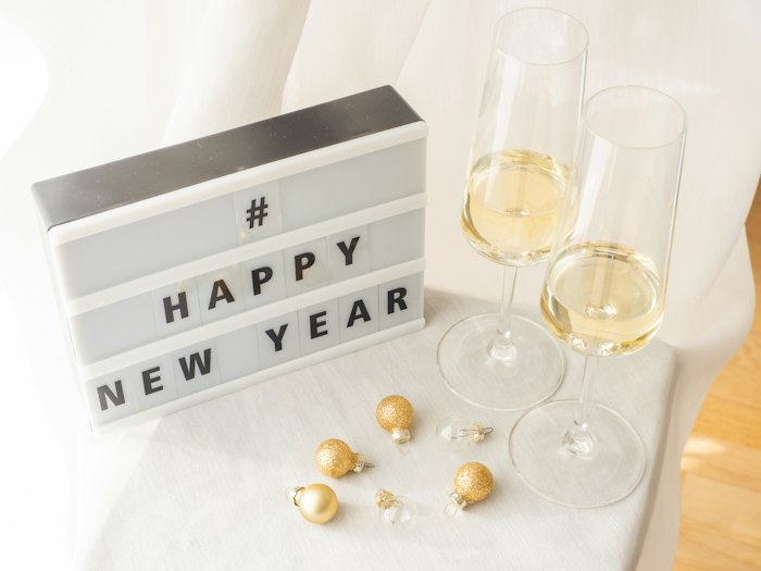 A Happy New Year lightbox sign with two glasses of champagne