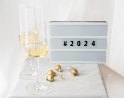 Sign with 2024 on it and two champagne glasses next to it