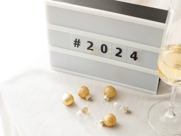 a glass of wine next to some earrings