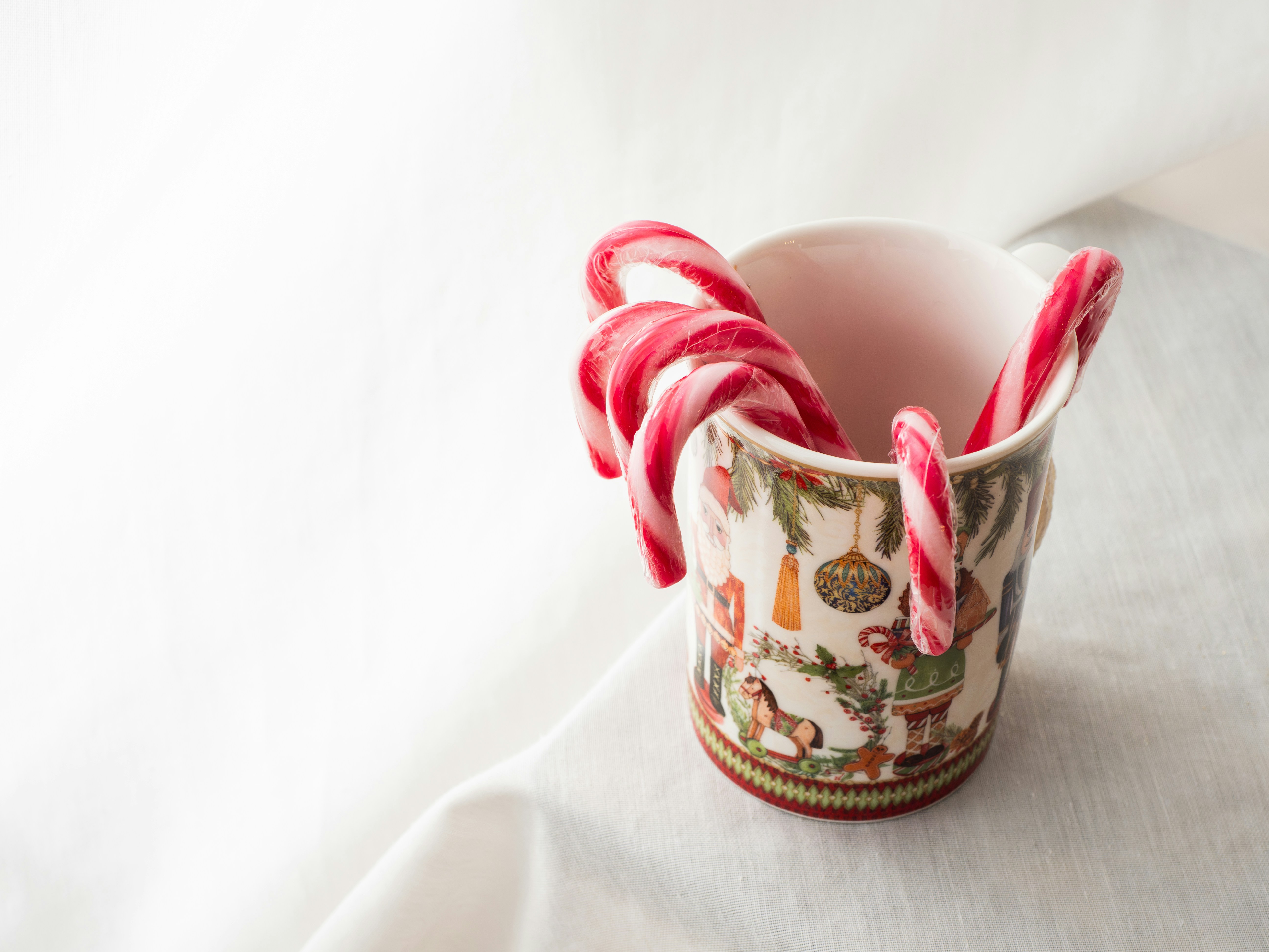a cup with candy canes in it sitting on a table