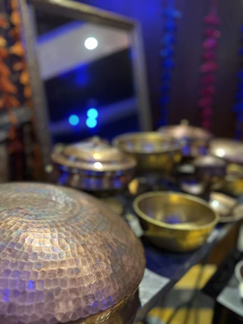 A copper serving bowl catching soft light, set beside a festive spread with candles and linen napkins.