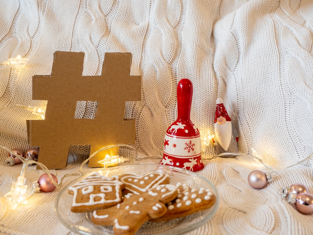 a plate of gingerbread cookies next to a gingerbread house