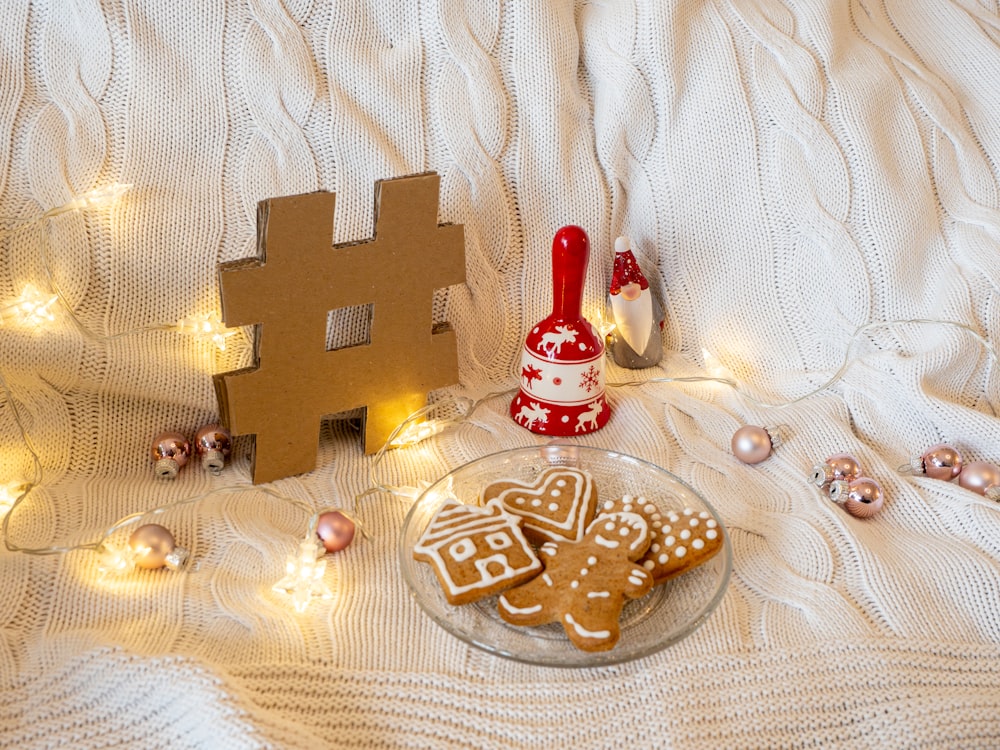 a plate of gingerbreads next to a gingerbread house