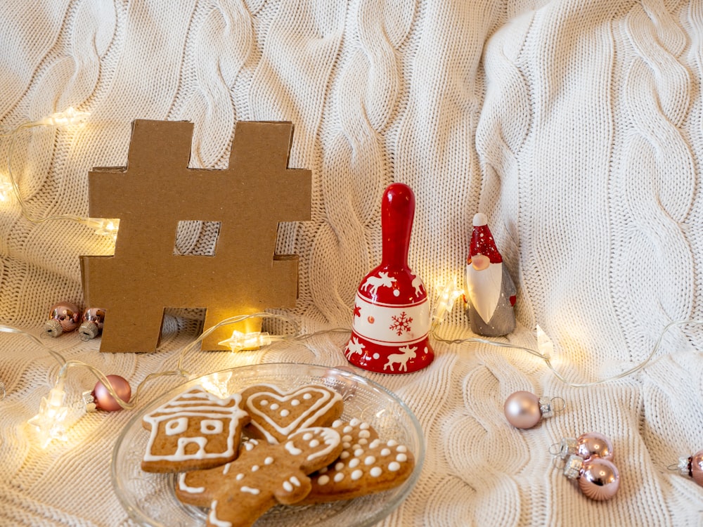 a plate of gingerbreads on a bed next to a gingerbread house