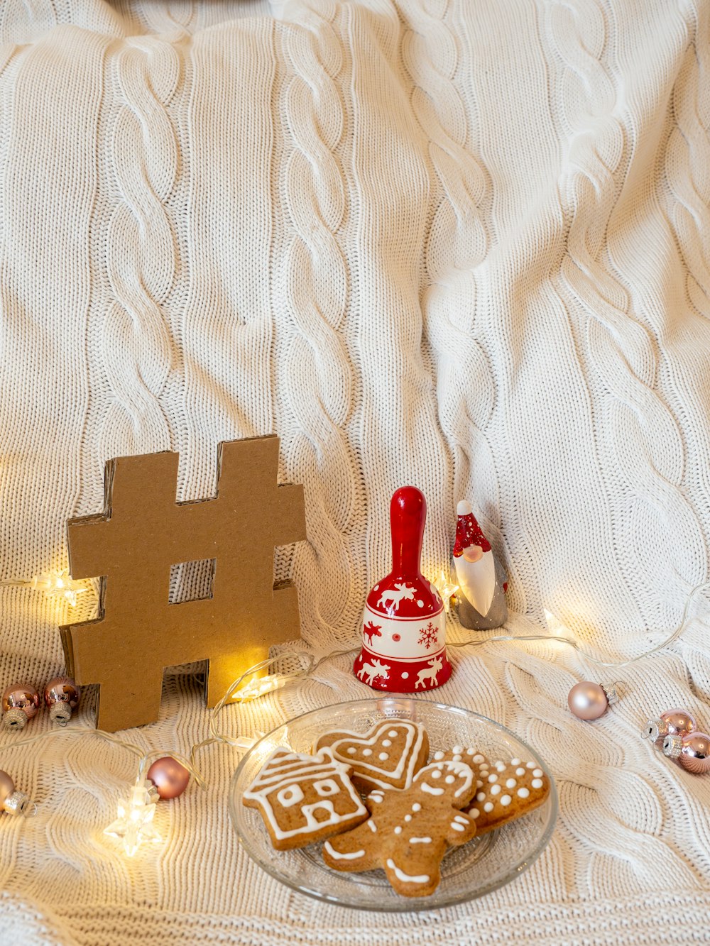 a plate of gingerbread cookies next to a gingerbread house