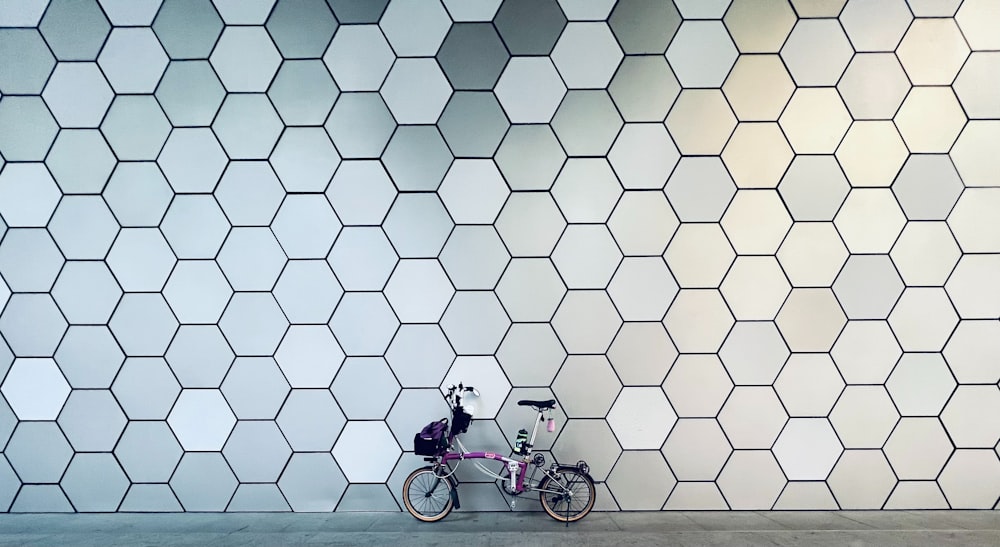 a bike parked against a wall with a pattern on it