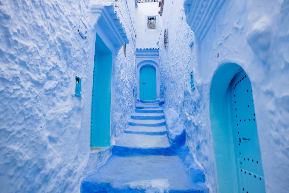 a narrow alley way with blue painted steps