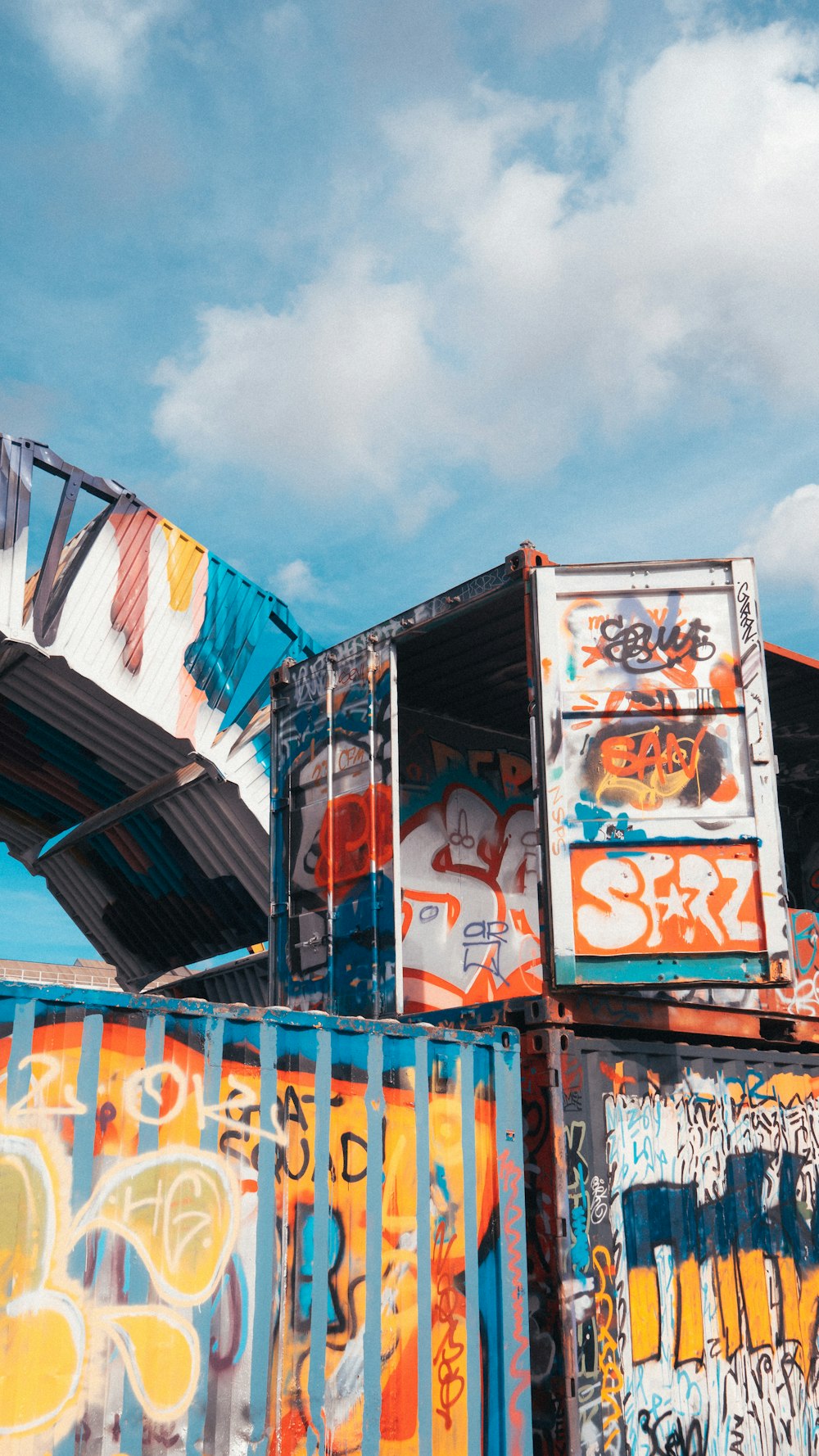 a bunch of containers that are covered in graffiti