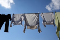Sunlight casting warm shadows over finished swimsuits hanging to dry.