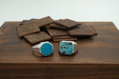 Stack of trendy men's rings in gold and silver arranged artistically on a wooden surface.