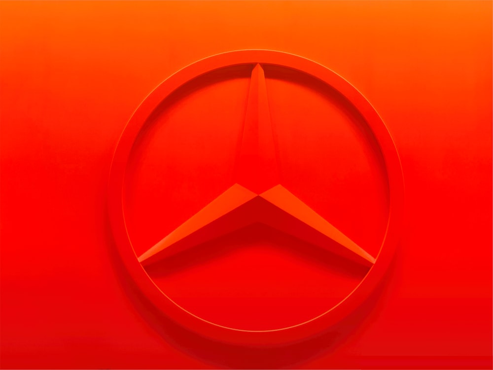 a red mercedes emblem on a red background