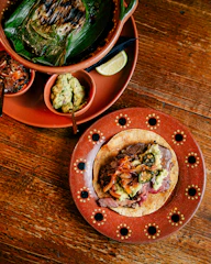 A colorful spread of traditional Mexican home-cooked dishes served family-style on a rustic wooden table.
