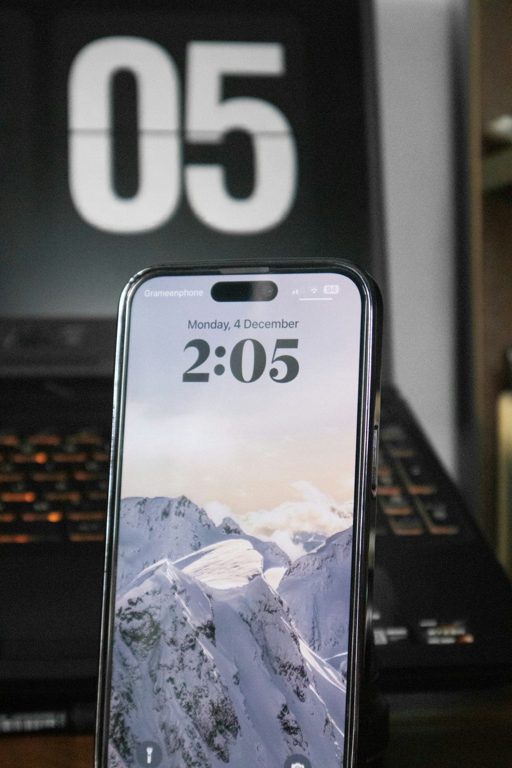 a cell phone sitting on top of a desk next to a laptop