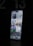 A modern smartphone is displayed with a lit-up screen showing various app icons, including weather, calendar, and social media applications, against a dark background. The screen's brightness highlights the device's sleek design.