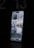 A modern smartphone is displayed with a lit-up screen showing various app icons, including weather, calendar, and social media applications, against a dark background. The screen's brightness highlights the device's sleek design.