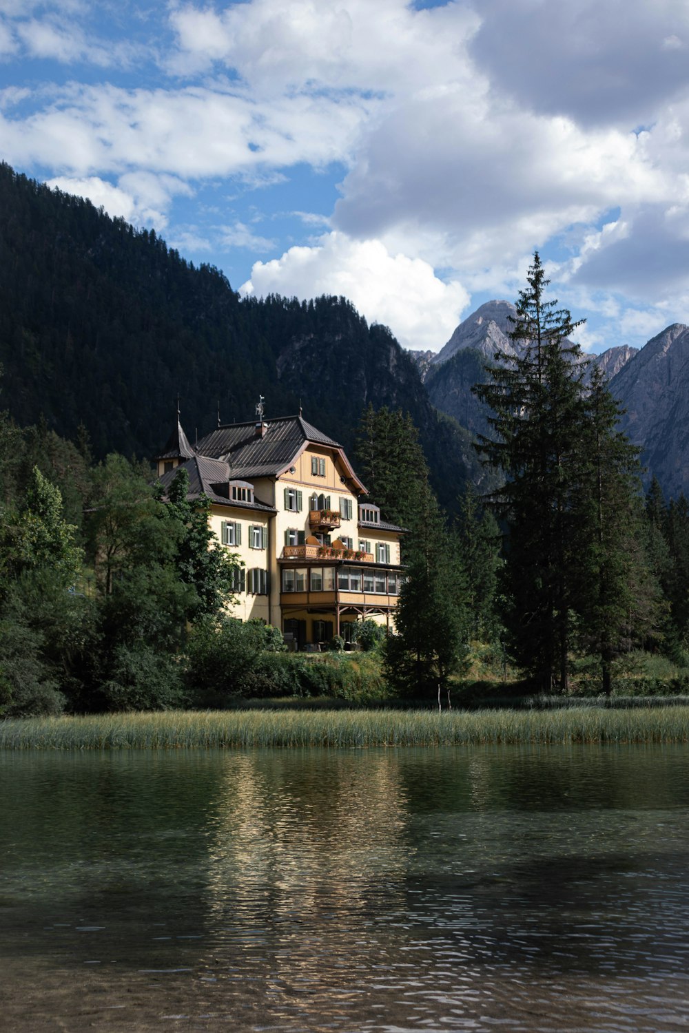 a large house sitting on top of a lush green hillside