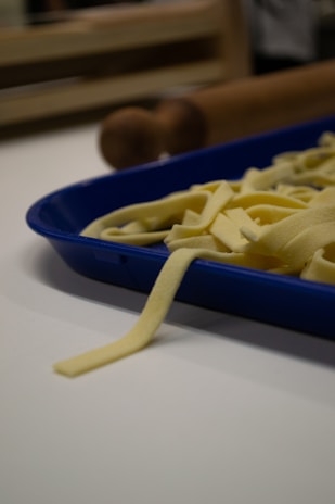 Close-up of fresh pasta dough being rolled out on a wooden surface