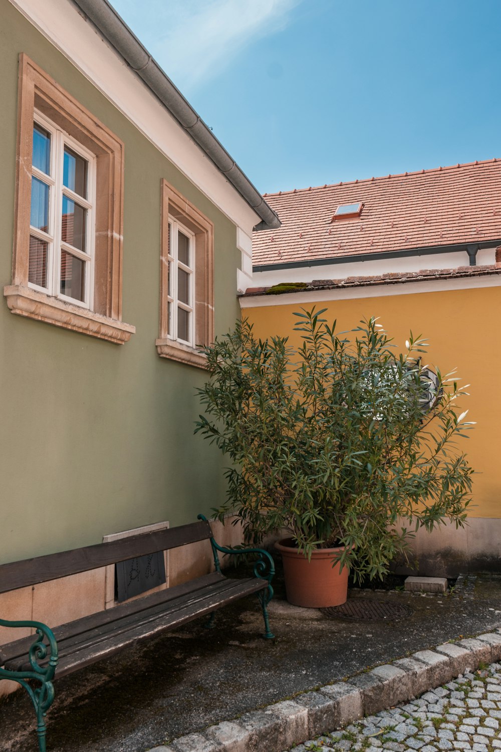 a wooden bench sitting next to a building