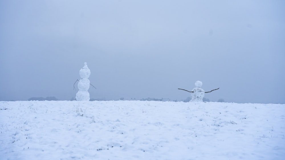 a couple of snowmen that are standing in the snow
