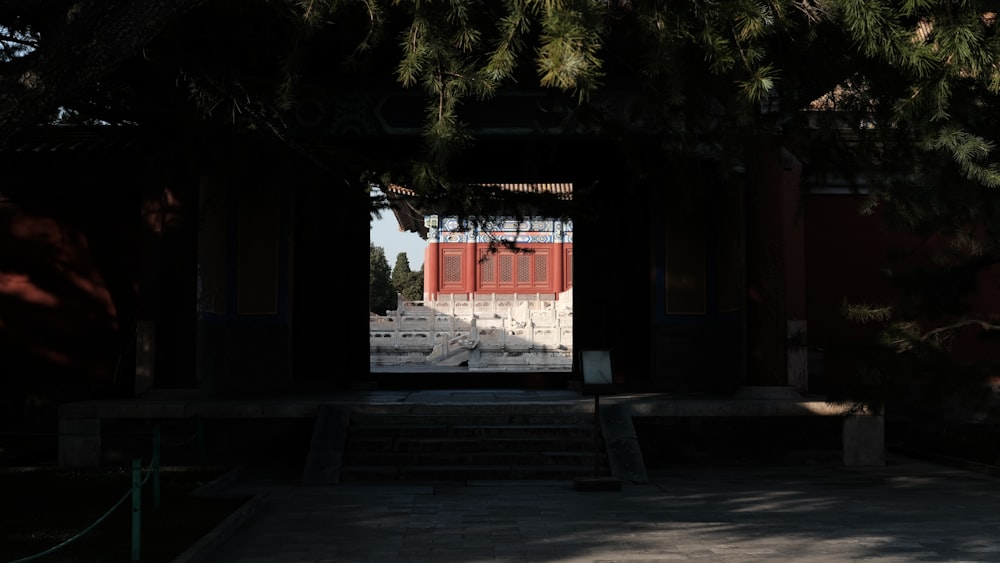 an open door to a building with pine trees in front of it