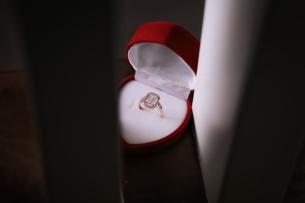 a ring sits in a red box on a table