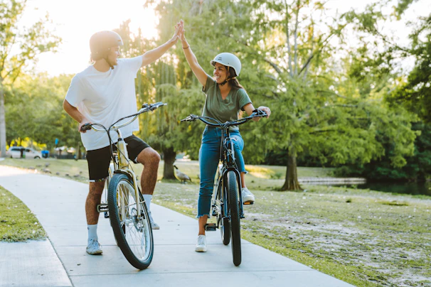 Smiling couple wearing helmets preparing to ride their rented bikes steps from Central Park’s entrance.