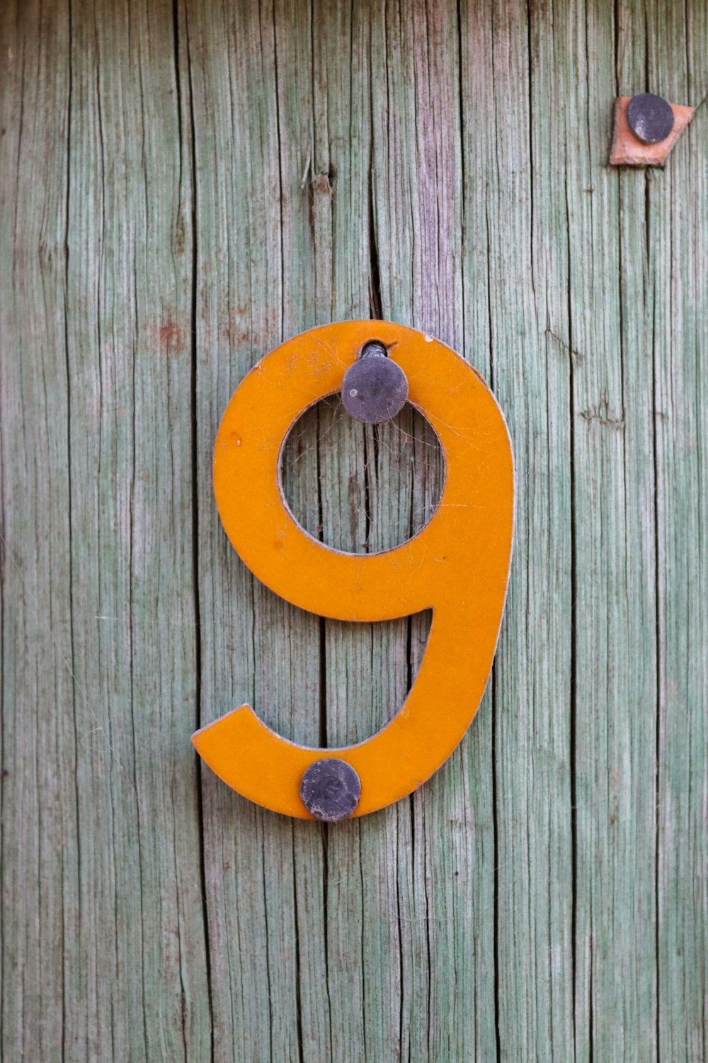 a wooden door with a metal letter g on it