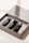A close-up of an open box containing three small black bottles with labels that read 'travel kit'. The kit appears to be a mockup template or cosmetic set with a clean and minimalist design.