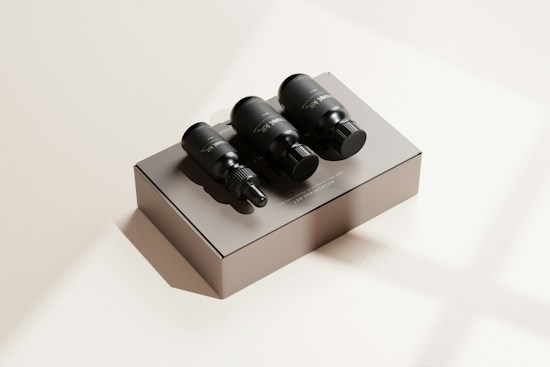 Three black dropper bottles are placed on a matte beige box with subtle shadows. The scene is minimalistic, featuring a neutral background with a soft lighting effect that creates a calm and luxurious appearance.