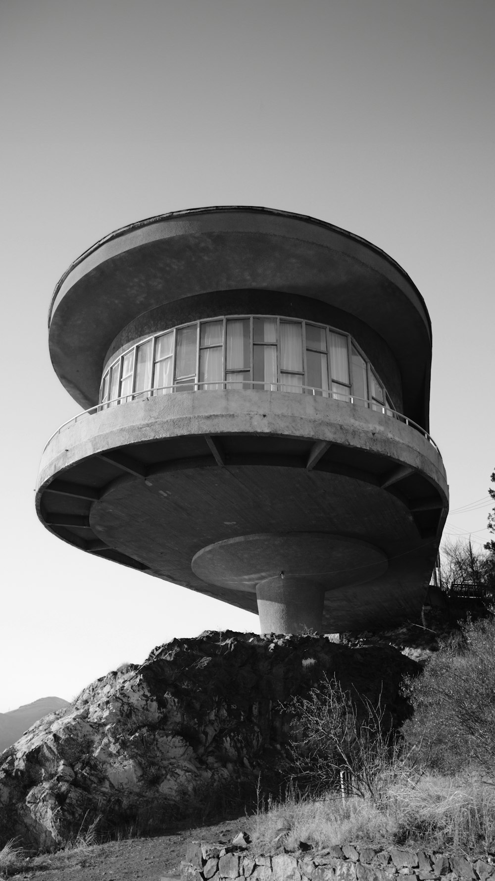 a black and white photo of a building on a hill