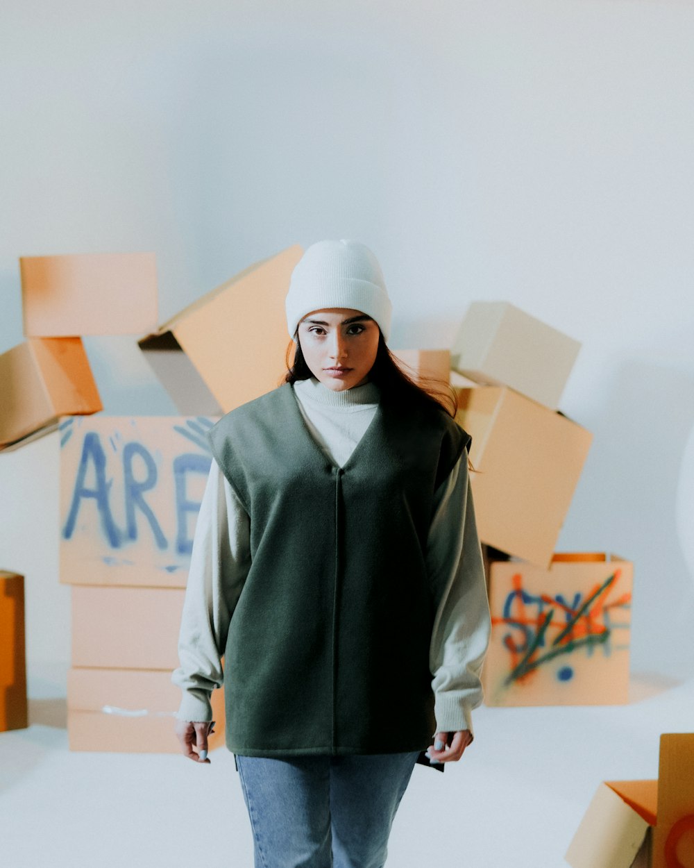 a woman standing in front of a pile of boxes