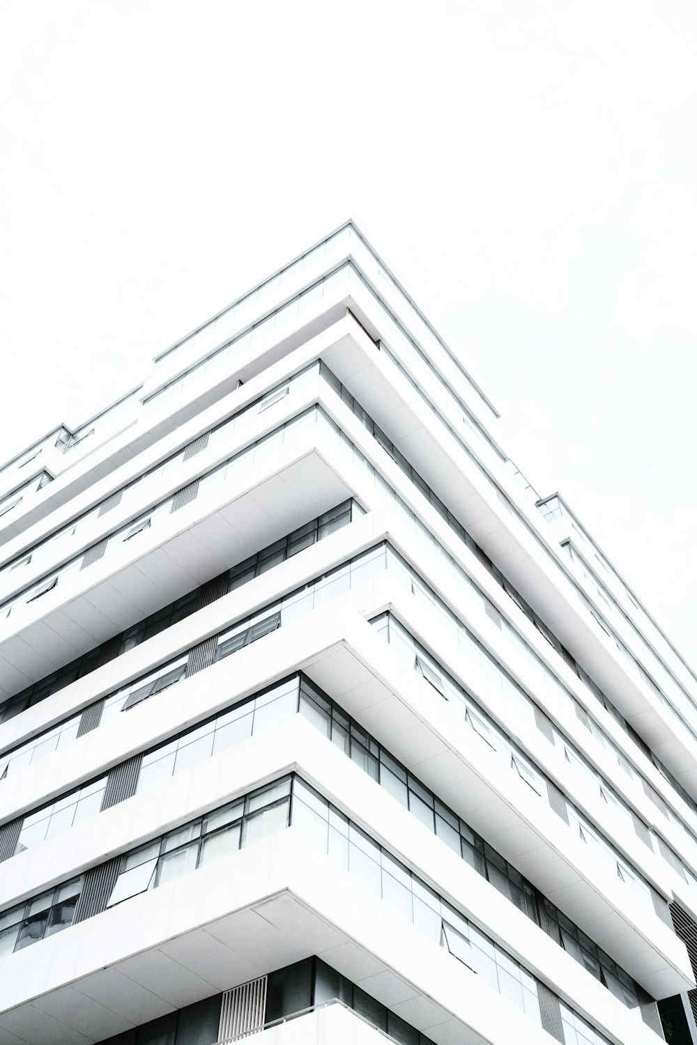 a tall white building sitting next to a traffic light