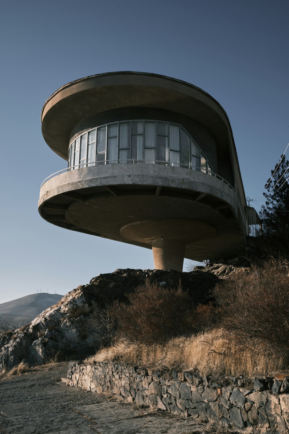 a round building with a balcony on top of a hill