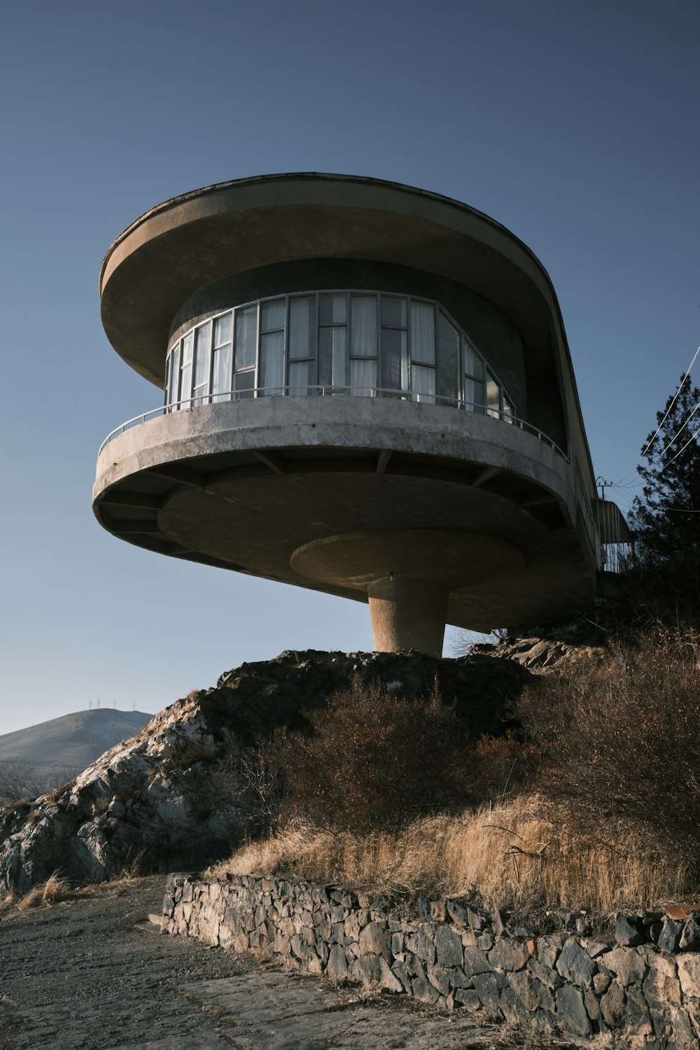 un edificio rotondo con un balcone in cima a una collina