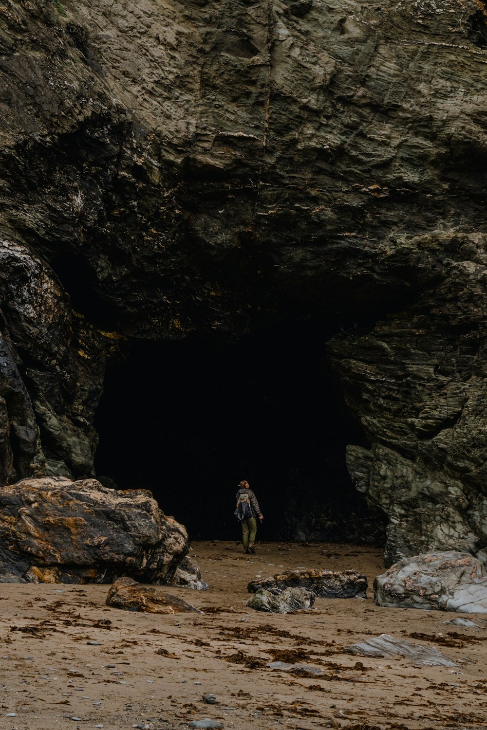 a person standing in front of a cave