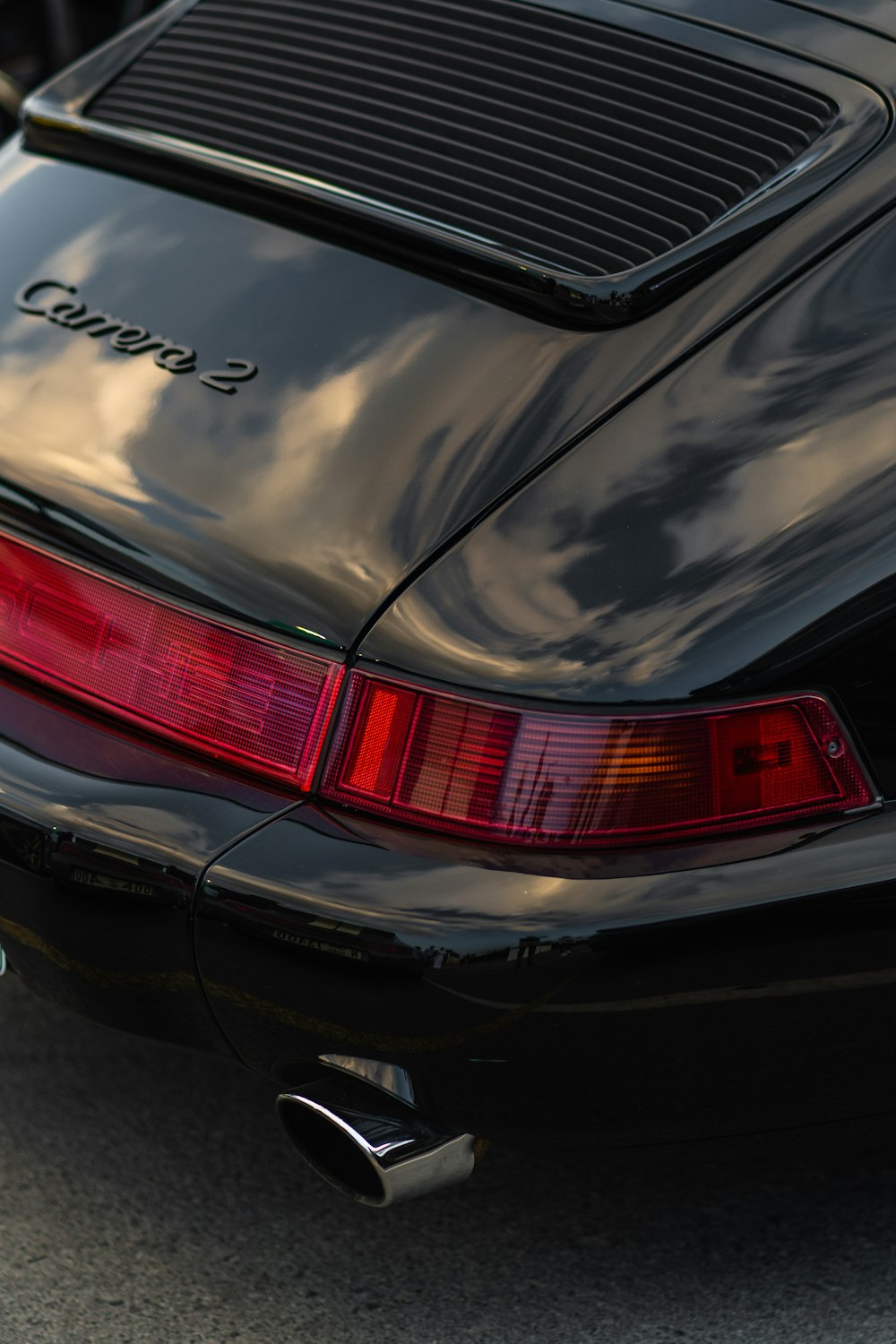 a close up of the tail lights of a black sports car