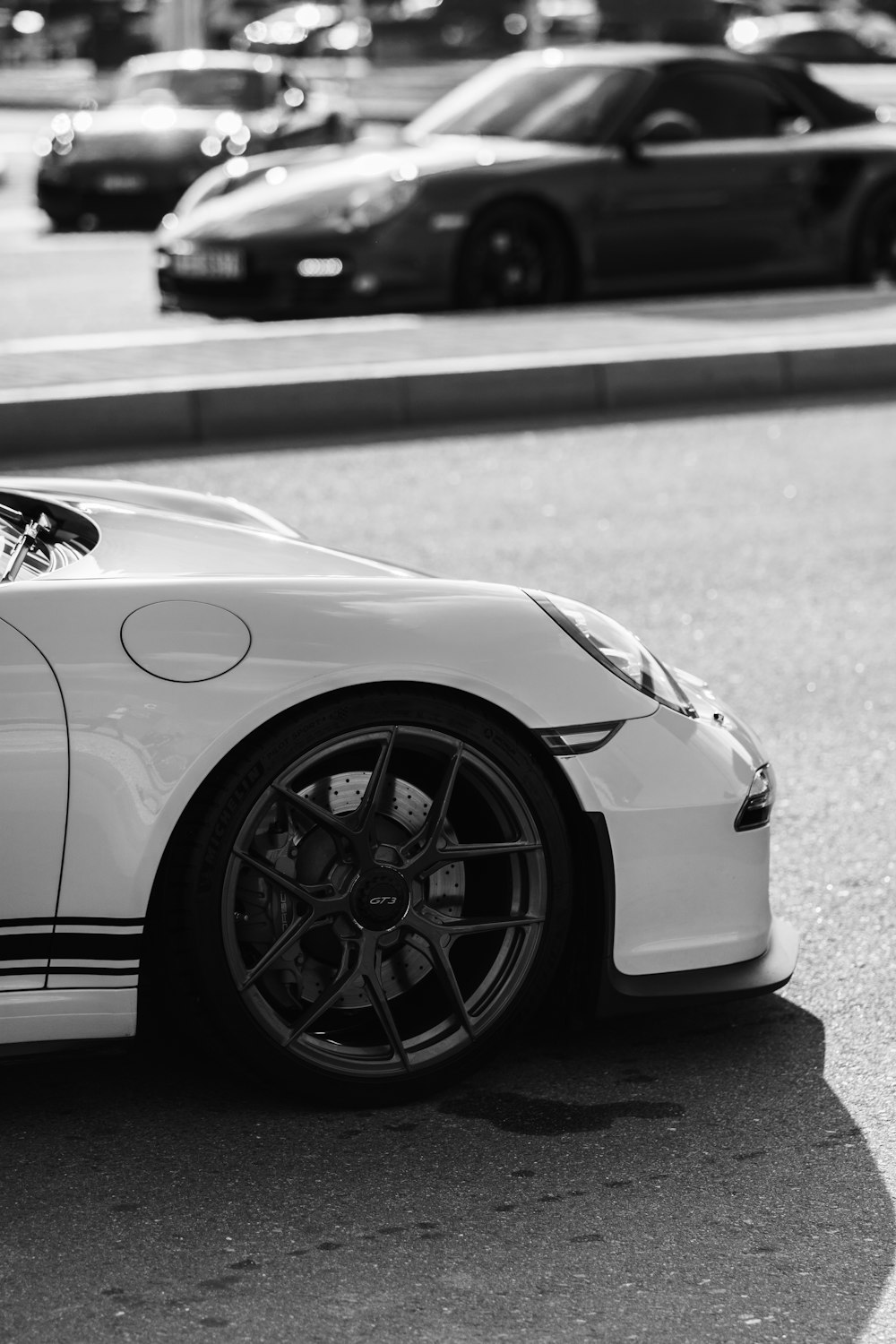 a white sports car parked on the side of the road