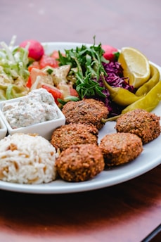 a plate of food that includes rice, meatballs, and salad