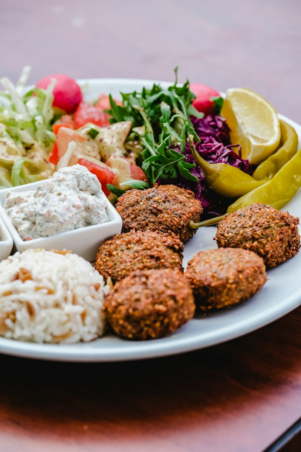 a plate of food that includes rice, meatballs, and salad