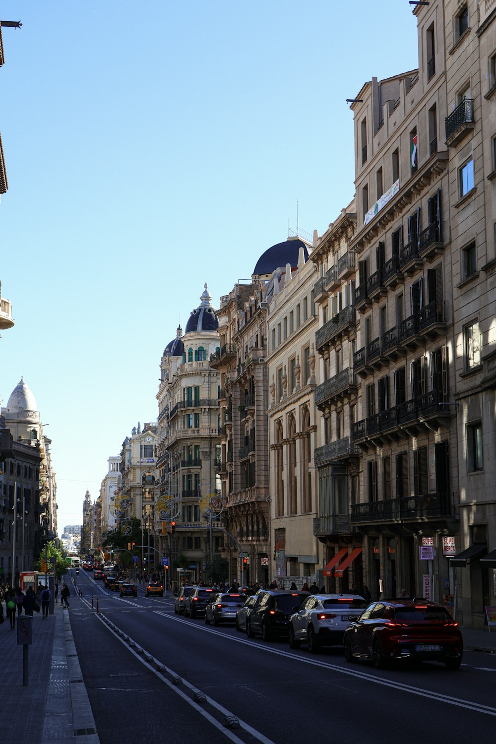 a city street lined with tall buildings and parked cars