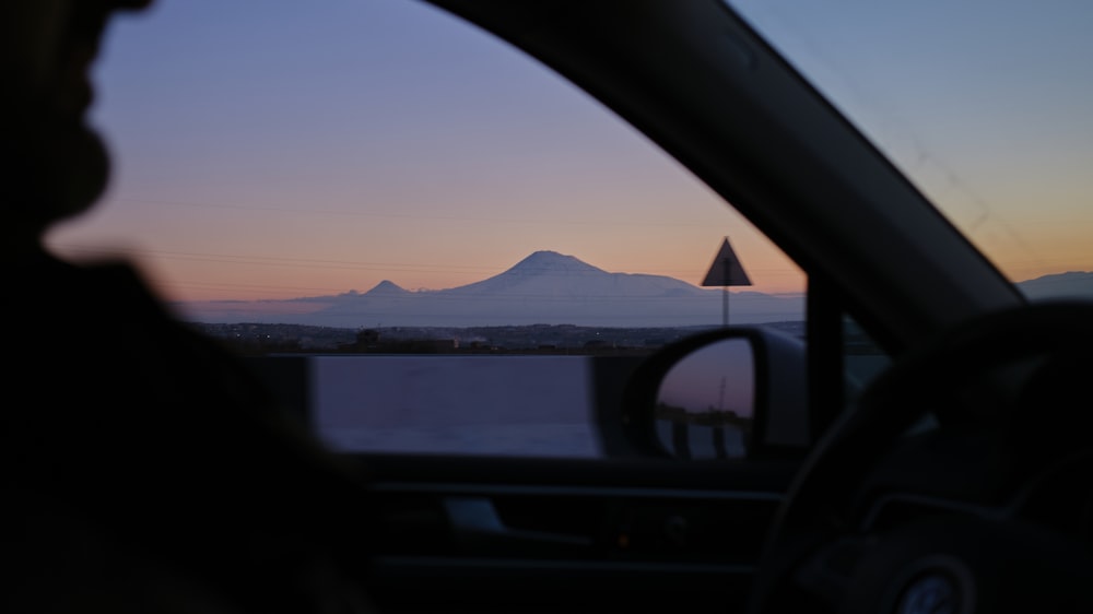 a view of a mountain from inside a car