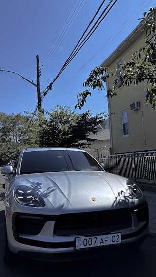 A shiny used sedan parked in front of a cozy Vijayawada neighborhood.