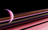 A celestial scene featuring a planet with a pink hue partially visible on the left, surrounded by a series of rings that extend horizontally across the image. The rings display varying shades of pink, brown, and white, set against the backdrop of deep space.