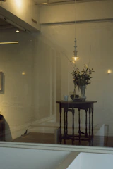 Minimalist floral arrangement in a softly lit café interior with neutral tones.