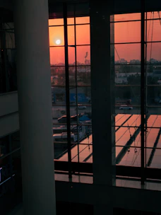 Sunset view from a stylish condo living room with large windows.