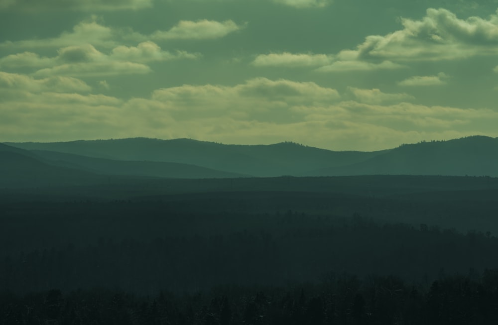 a view of a mountain range with trees in the foreground